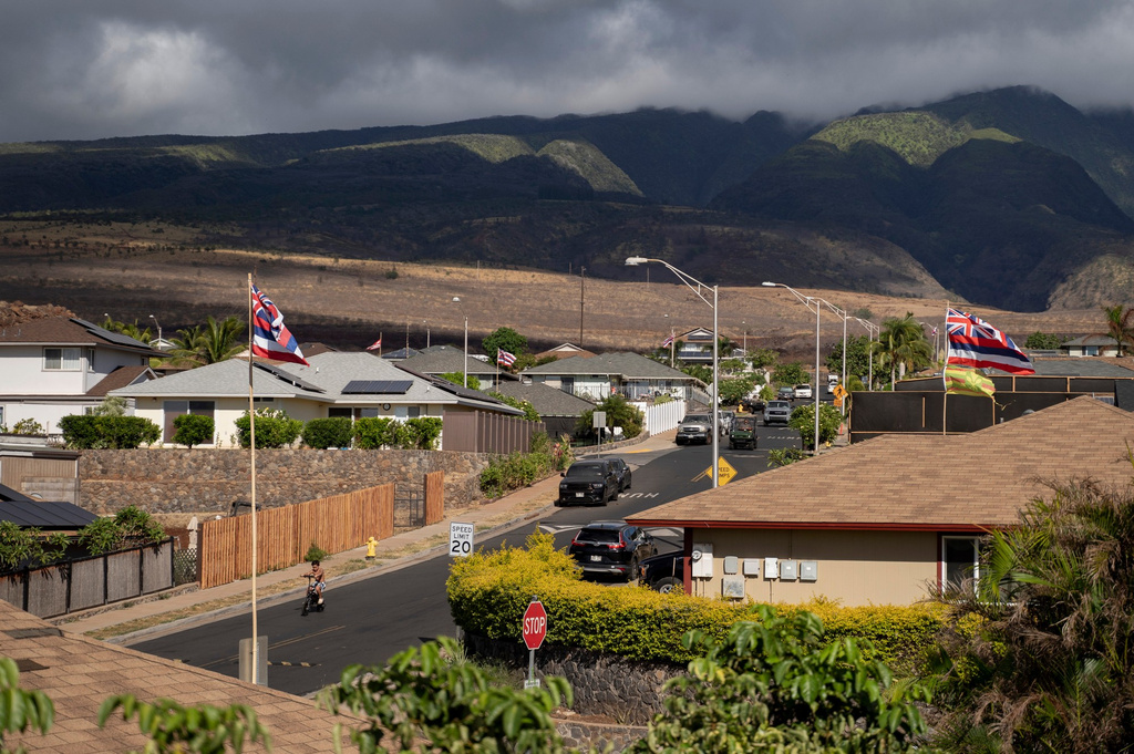 FILE - A child rides a bicycle on Aipuni Street in the Villages of Leiali'i, a Hawaiian homestead community, on Monday, Sept. 25, 2023, in Lahaina, Hawaii. (AP Photo/Mengshin Lin, File)