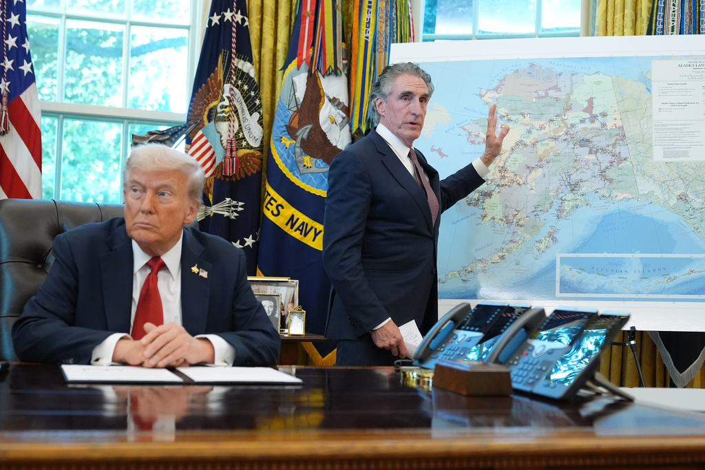 President Donald Trump listens as Interior Secretary Doug Burgum speaks to reporters in the Oval Office at the White House, Monday, Oct. 6, 2025, in Washington. (AP Photo/Jacquelyn Martin)