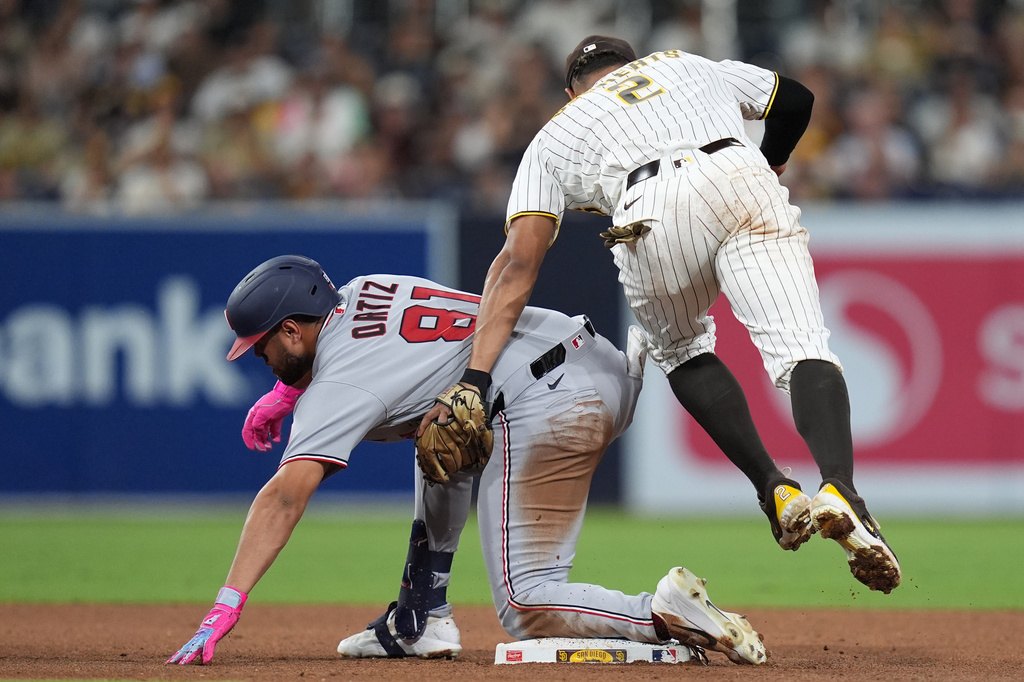 San Diego Padres shortstop Xander Bogaerts (2) applies the tag too late as Washington Nationals' Abimelec Ortiz arrives safely to second base with a double during the sixth inning of a baseball game Tuesday, Sept. 8, 2026, in San Diego. (AP Photo/Gregory Bull)