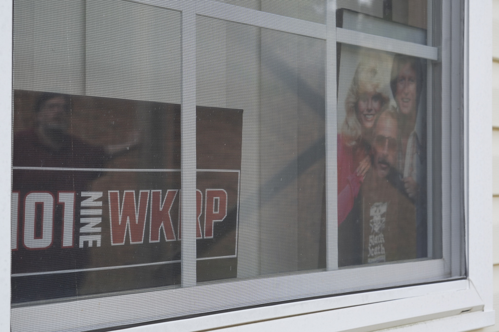 A photo of the cast members of the sitcom "WKRP in Cincinnati" sits in a window at the home of D.P. McIntire in Raleigh, N.C., on Thursday, April 2, 2026. (AP Photo/Allen G. Breed)