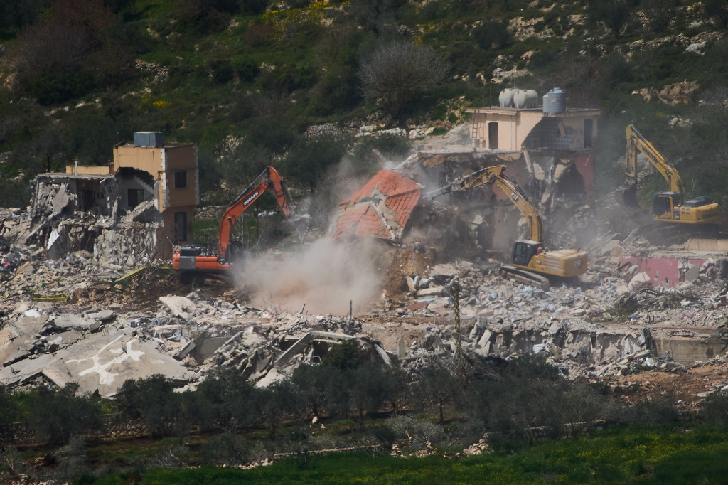 Israeli bulldozers demolish homes in southern Lebanon, as seen from northern Israel, Sunday, April 12, 2026. (AP Photo/Ariel Schalit)