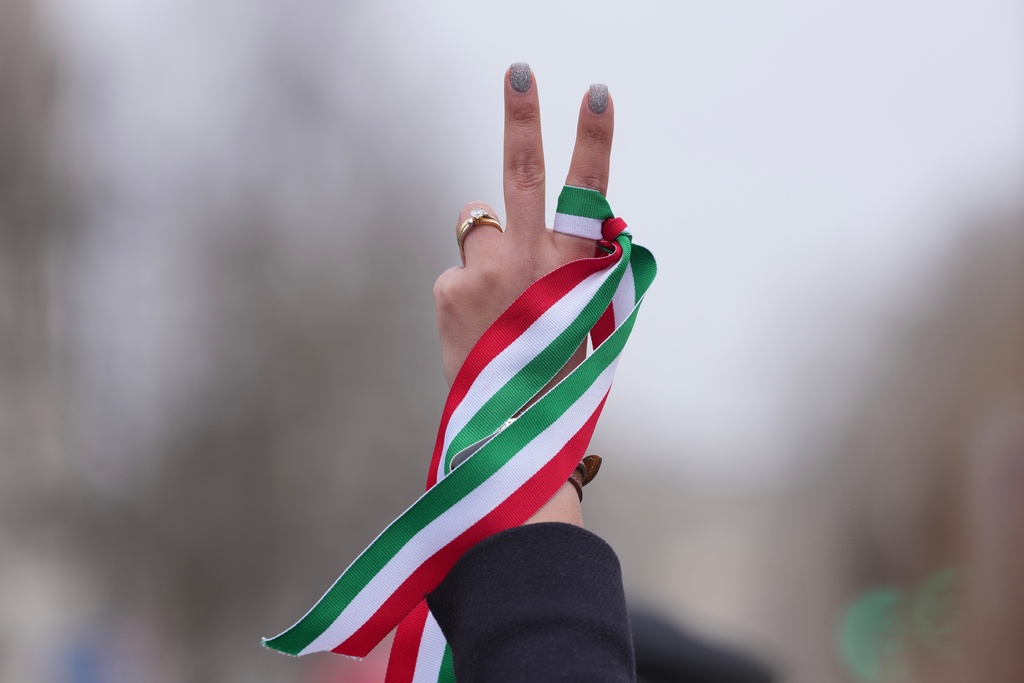 A protester holds Iranian ribbon as she demonstrates outside the parliament in London, Wednesday, March 4, 2026. (AP Photo/Kin Cheung)