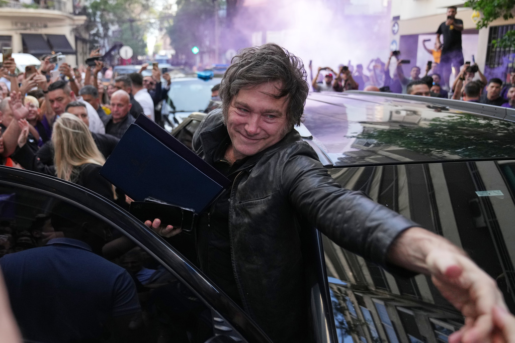 Argentine President Javier Milei waves to supporters upon arriving at a hotel in Rosario, Argentina, Thursday, Oct. 23, 2025. (AP Photo/Rodrigo Abd)