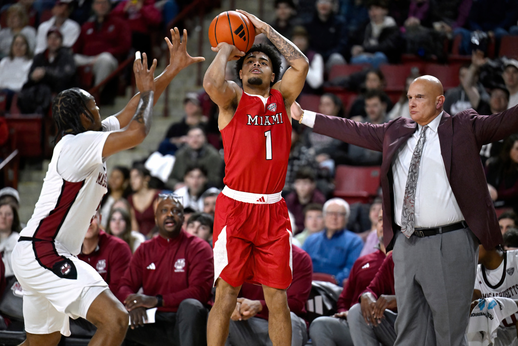 Miami Ohio guard Trey Perry shoots as UMass guard K'Jei Parker, left, defends and UMass head coach Frank Martin looks on, in the first half of an NCAA college basketball game, Tuesday, Feb. 17, 2026, in Amherst, Mass. (AP Photo/Jessica Hill)
