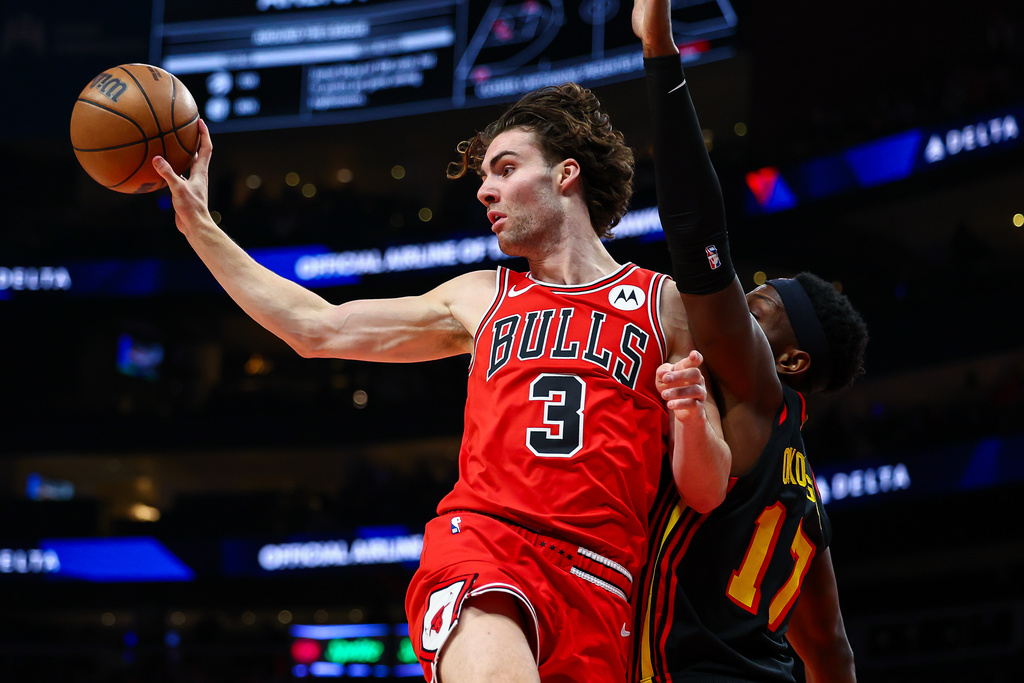 Chicago Bulls guard Josh Giddey passes while Atlanta Hawks forward Onyeka Okongwu, right, defends during the first half of an NBA basketball game, Sunday, Dec. 21, 2025, in Atlanta. (AP Photo/Colin Hubbard)