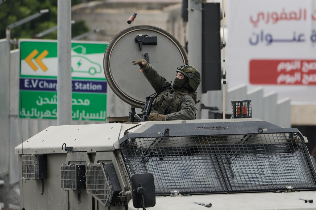 An Israeli soldier throws a stun grenade during clashes with Palestinian demonstrators in the West Bank city of Nablus, Sunday, May 3, 2026. (AP Photo/Majdi Mohammed)