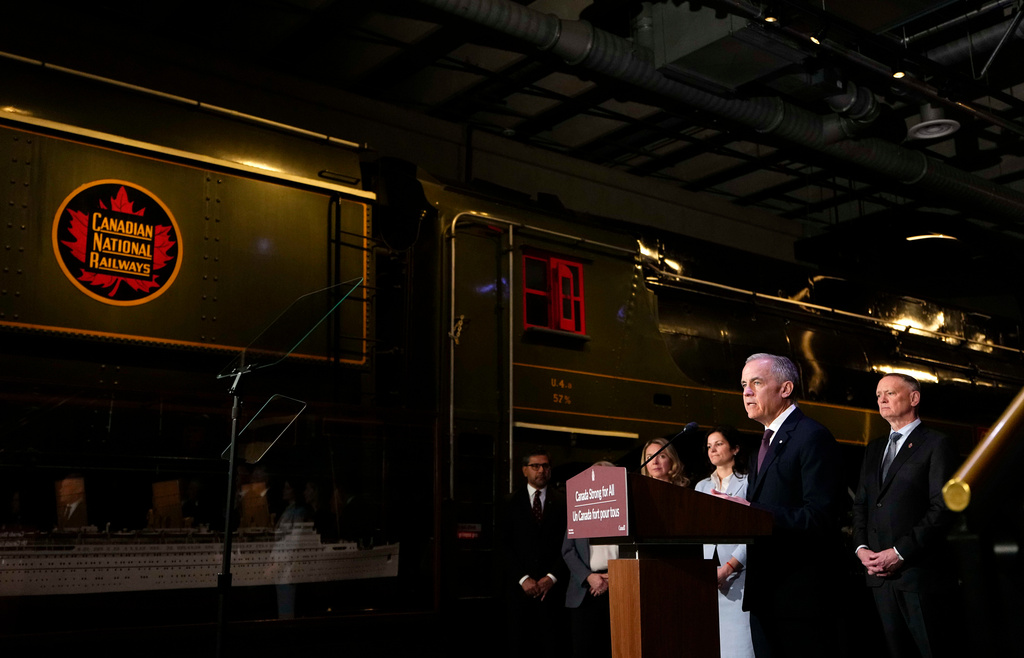 Canada Prime Minister Mark Carney speaks from a lectern beside a Canadian National Railways locomotive at the Canada Science and Technology Museum, during an announcement on the Canada Strong Fund, Canada's first sovereign wealth fund in Ottawa on Monday, April 27, 2026. (Justin Tang/The Canadian Press via AP)