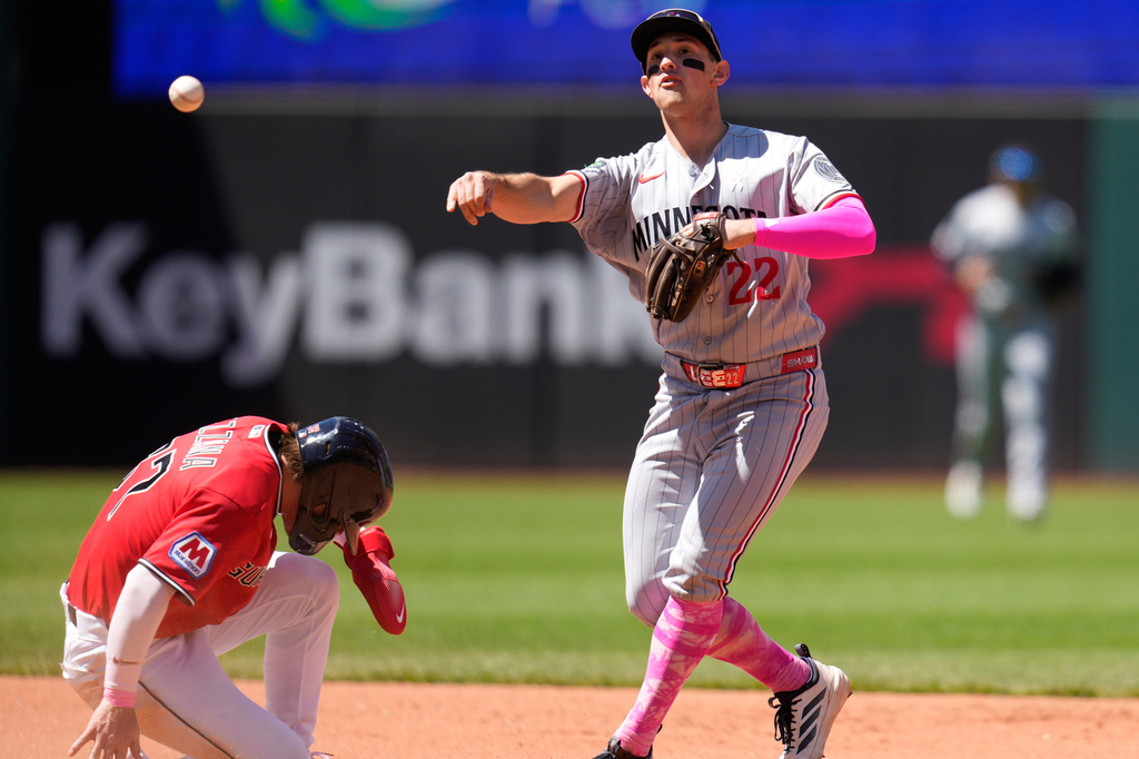 Minnesota Twins shortstop Brooks Lee, right, forces out Cleveland Guardians' Travis Bazzana, left, at second base and completes the throw to first base for the out on Patrick Bailey on a double play ball in the fourth inning of a baseball game in Cleveland, Sunday, May 10, 2026. (AP Photo/Sue Ogrocki)