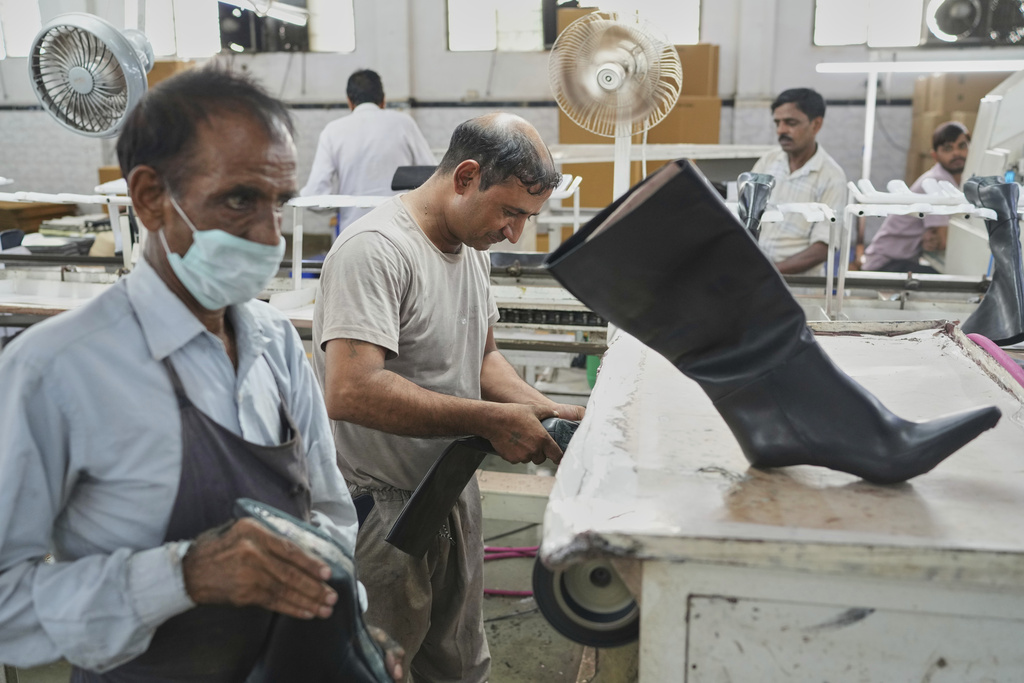Workers in a manufacturing unit make leather footwear in Agra, India, Monday, Aug. 25, 2025. (AP Photo/Manish Swarup)