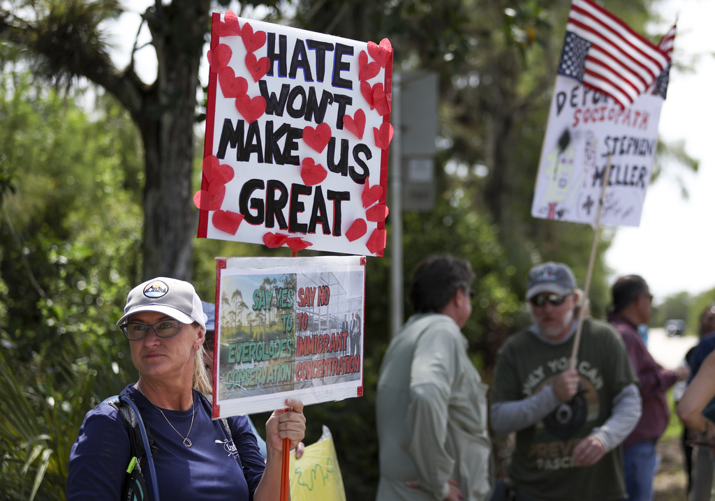 A protester stands outside the migrant detention facility dubbed &quot;Alligator Alcatraz&quot; at the Dade-Collier Training and Transition Facility, Saturday, July 12, 2025, in Ochopee, Fla. (AP Photo/Alexandra Rodriguez)