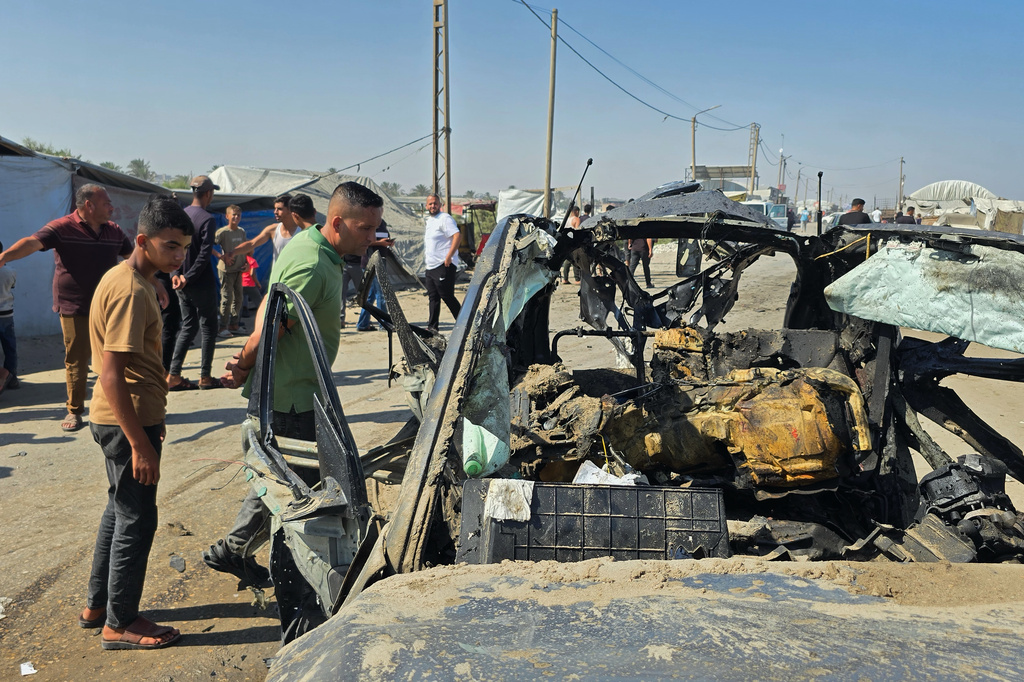 Palestinians look at a destroyed car following an Israeli military strike in Khan Younis, southern Gaza Strip, Monday, July 6, 2026, that, according to hospital officials, killed at least one person. (AP Photo/Mohammad Jahjouh)