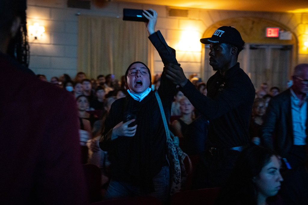 A pro-Palestinian protester is escorted out of former Vice President Kamala Harris' book launch event for her new book about her presidential campaign, "107 Days," at Town Hall in New York, Wednesday, Sept. 24, 2025. (AP Photo/Angelina Katsanis)