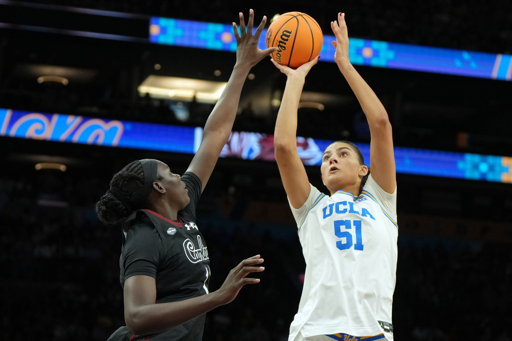 UCLA center Lauren Betts (51) shoots over South Carolina center Madina Okot (11) during the second half of the women's National Championship Final Four NCAA college basketball tournament game, Sunday, April 5, 2026, in Phoenix. (AP Photo/Rick Scuteri)