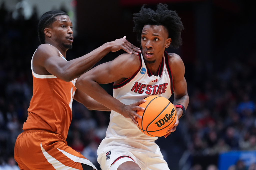 FILE - North Carolina State guard Paul McNeil Jr., right, drives to the basket as Texas guard Tramon Mark, left, defends, during the first half in a First Four college basketball game in the NCAA Tournament, March 17, 2026, in Dayton, Ohio. (AP Photo/Kareem Elgazzar, File)