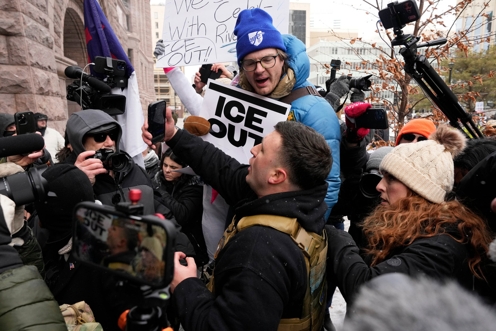 Pro-immigration protesters confront Jake Lang, center, who organized the protest March Against Minnesota Fraud, in front of Minneapolis City Hall, Saturday, Jan. 17, 2026, in Minneapolis. (AP Photo/Yuki Iwamura)