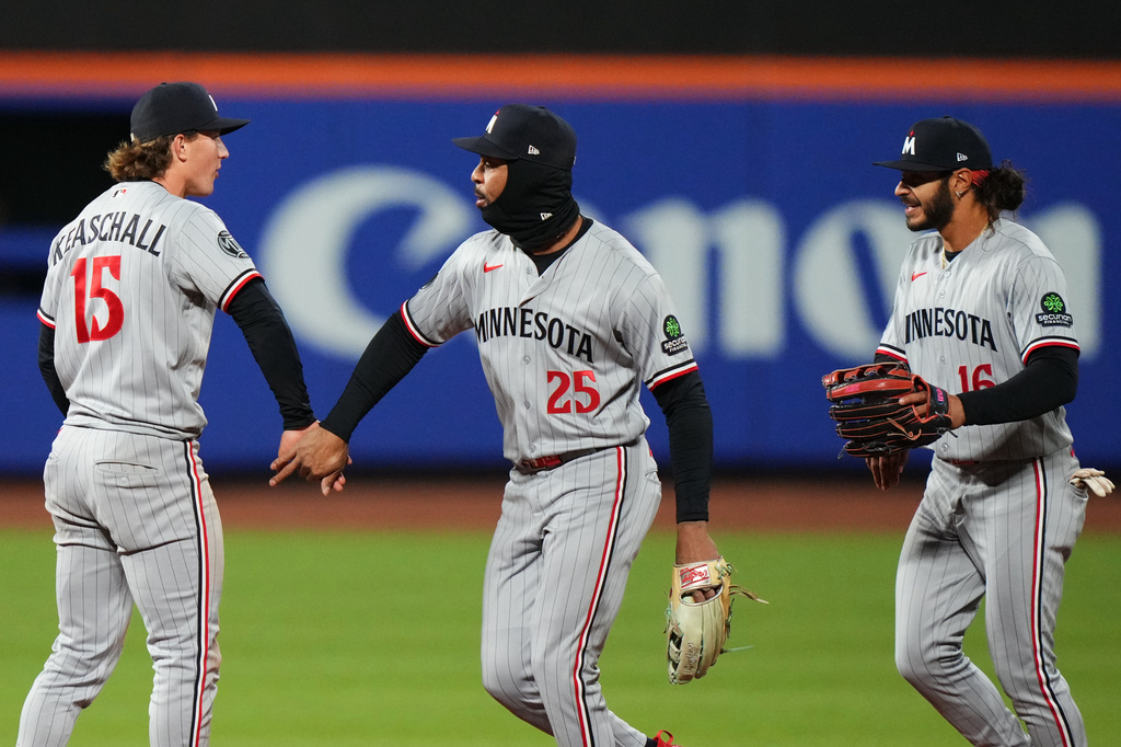 Minnesota Twins' Luke Keaschall (15) celebrates with teammates Byron Buxton (25) andn Austin Martin (16) after a baseball game against the New York Mets Tuesday, April 21, 2026, in New York. (AP Photo/Frank Franklin II)