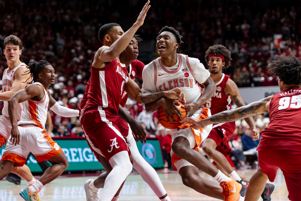 Clemson guard Zac Foster (5) drives into coverage by Alabama guard Davion Hannah (4) during the first half of an NCAA college basketball game, Wednesday, Dec. 3, 2025, in Tuscaloosa, Ala. (AP Photo/Laura Chramer)
