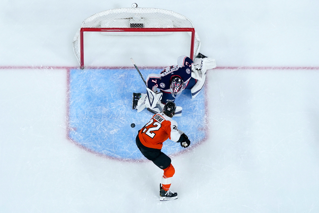 Philadelphia Flyers' Christian Dvorak, bottom, can not get a shot past Columbus Blue Jackets' Jet Greaves during the second period of an NHL hockey game Tuesday, March 24, 2026, in Philadelphia. (AP Photo/Matt Slocum)