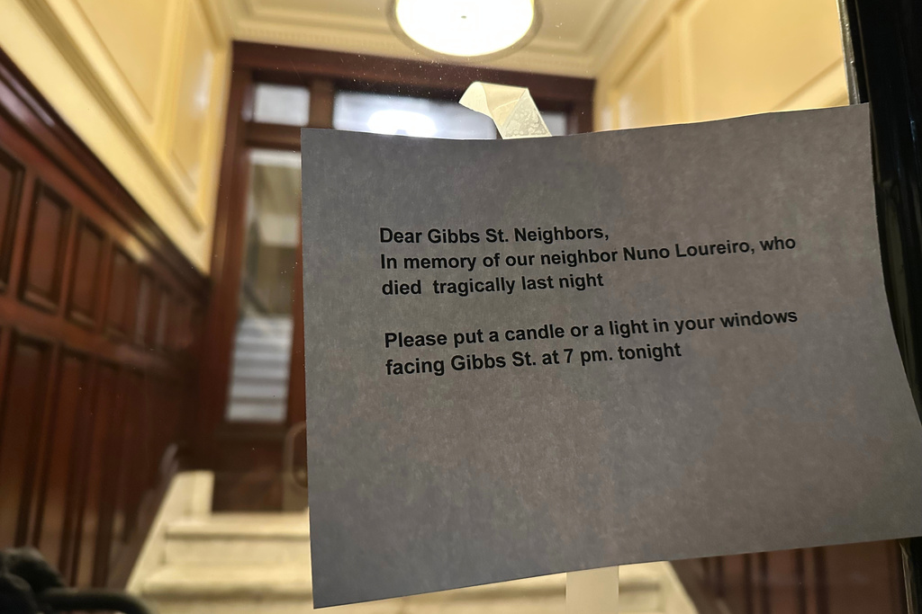 A notice encouraging neighbors of Massachusetts Institute of Technology professor Nuno F.G. Loureiro to display candles in their windows to honor his life is taped to an apartment door in Brookline, Mass., Tuesday, Dec. 16, 2025. (AP Photo/Leah Willingham)