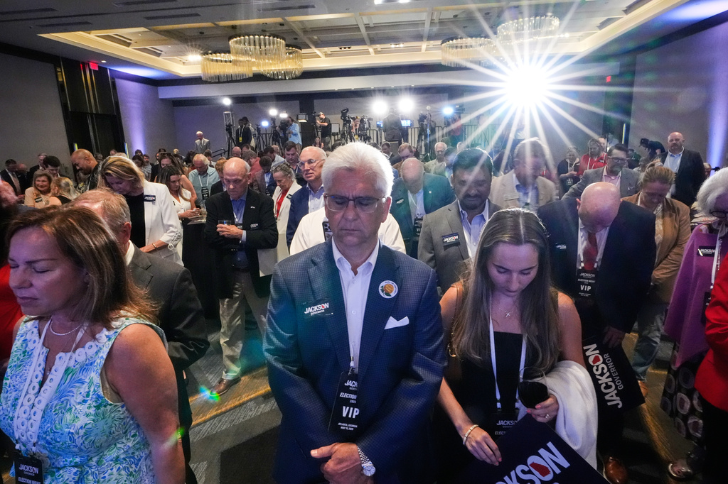 Supporters pray at a primary election night party for Georgia gubernatorial candidate Rick Jackson on Tuesday, May 19, 2026, in Atlanta. (AP Photo/Brynn Anderson)
