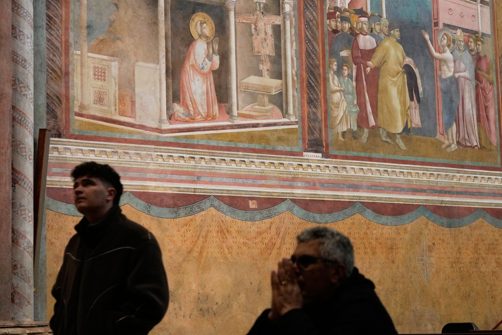 Faithful pray inside the Basilica of St. Francis in Assisi, Italy, Saturday, Feb. 21, 2026, on the eve of the public display of St. Francis' remains to mark the 800th anniversary of his death in 1226.(AP Photo/Gregorio Borgia)