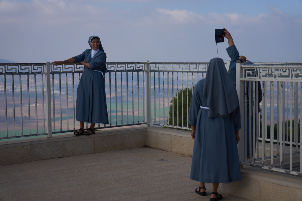 Nuns pose for photograph with the view from the Basilica of the Transfiguration on Mount Tabor, northern Israel, Aug. 6, 2026. (AP Photo/Ariel Schalit)