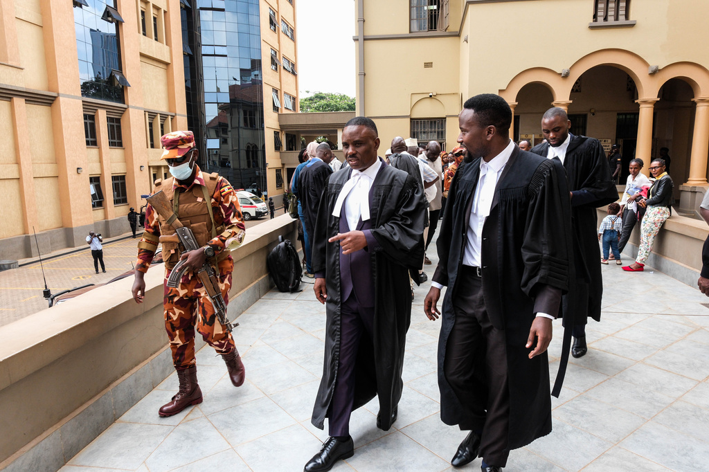 Erias Lukwago, center, lawyer for Uganda's veteran opposition leader Kizza Besigye, leaves the High Court in Kampala, Uganda, Monday, Dec. 29, 2025. (AP Photo/Hajarah Nalwadda)