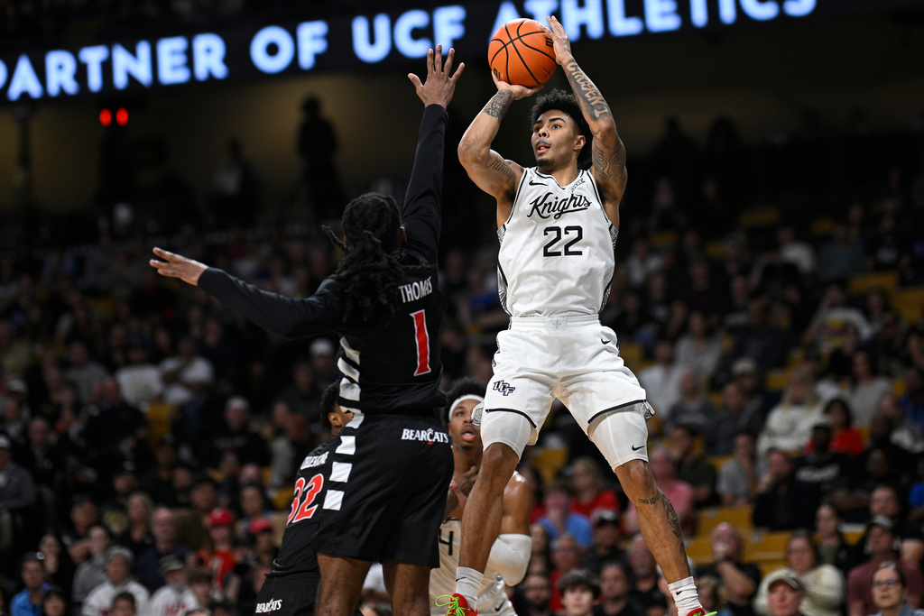 Central Florida guard Chris Johnson (22) goes up to shoot in front of Cincinnati guard Day Day Thomas (1) during the first half of an NCAA college basketball game, Sunday, Jan. 11, 2026, in Orlando, Fla. (AP Photo/Phelan M. Ebenhack)