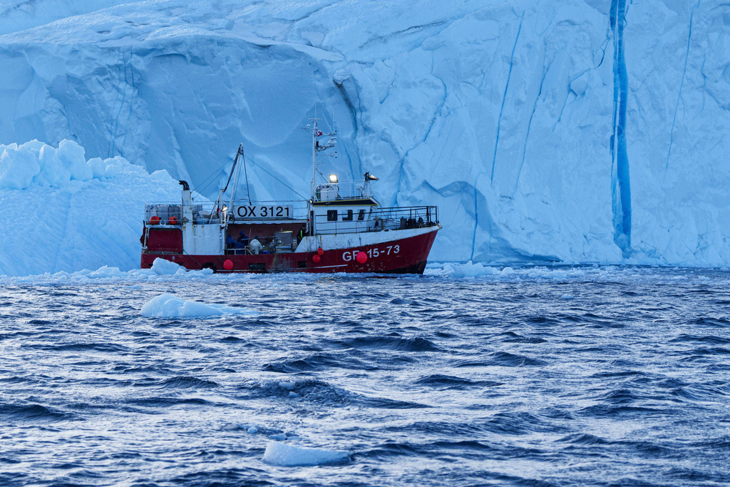 A fishing boat pulls a net up with fish in front of an iceberg at Disko Bay near Ilulissat, Greenland, on Thursday, Jan. 29, 2026. (AP Photo/Evgeniy Maloletka)