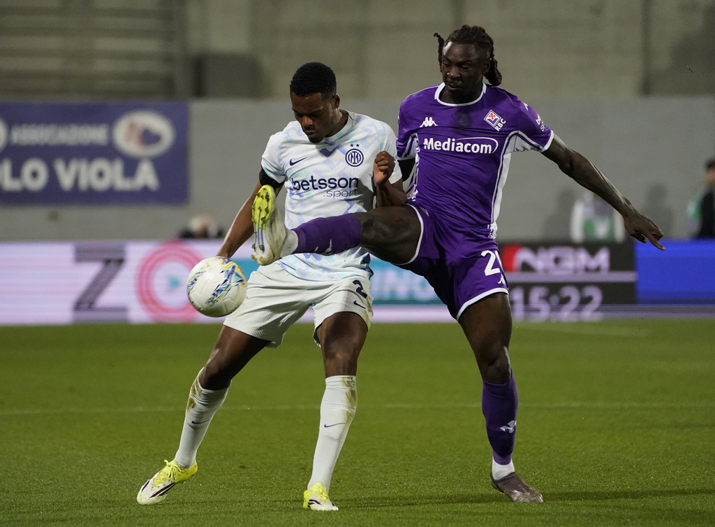 Inter's Denzel Dumfries, left, and Fiorentina's Moise Kean, right, challenge for the ball during the Serie A soccer match between Fiorentina and Inter Milan in Florence, Italy, Sunday, March 22, 2026. (Marco Bucco/LaPresse via AP)