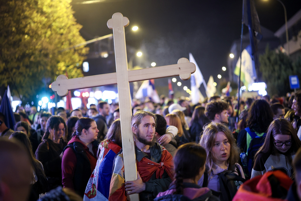 A person holds a cross as students march to Novi Sad for a rally on Nov. 1 marking the first anniversary of a train station disaster that killed 16 people, in Indjija, Serbia, Thursday, Oct. 30, 2025. (AP Photo/Armin Durgut)