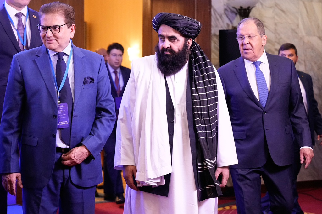 Russian Foreign Minister Sergey Lavrov, right, and Afghanistan's acting Foreign Minister Amir Khan Muttaqi, center, enter a hall for their talks in the Moscow format of consultations on Afghanistan in Moscow, Russia, Tuesday, Oct. 7, 2025. (AP Photo/Alexander Zemlianichenko)