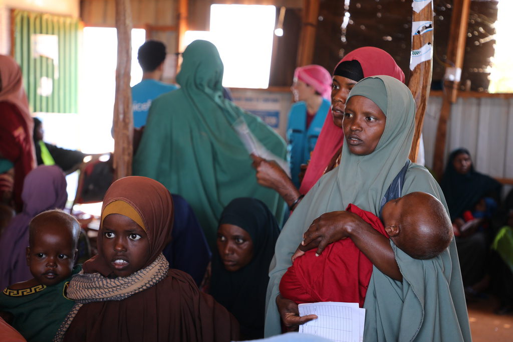 A Somali mother holds her malnourished child as she waits to receive therapeutic food at a UNICEF-funded nutrition center in Dolow, Somalia, Wednesday, March 25, 2026. (AP Photo/Mohamed Sheikh Nor)