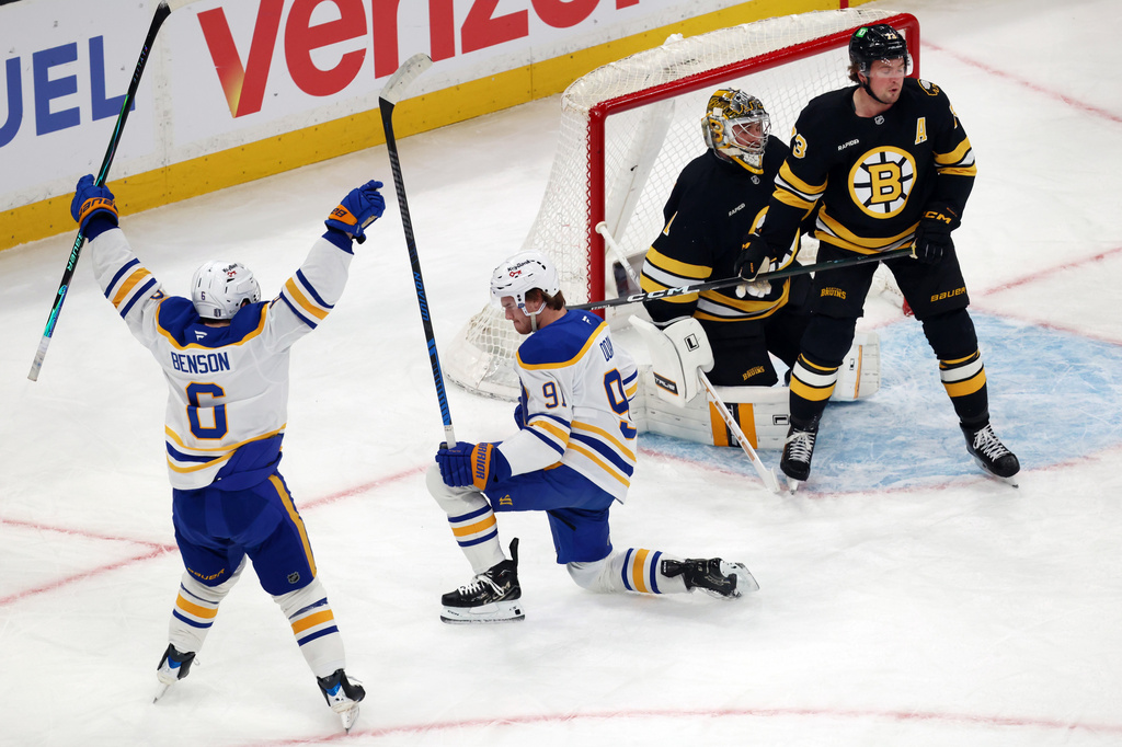 Buffalo Sabres' Josh Doan (91) celebrates his goal with Zach Benson (6) beside Boston Bruins' Jeremy Swayman (1) and Charlie McAvoy (73) during the first period in Game 4 of a first-round NHL hockey Stanley Cup playoff series, Sunday, April 26, 2026, in Boston. (AP Photo/Michael Dwyer)