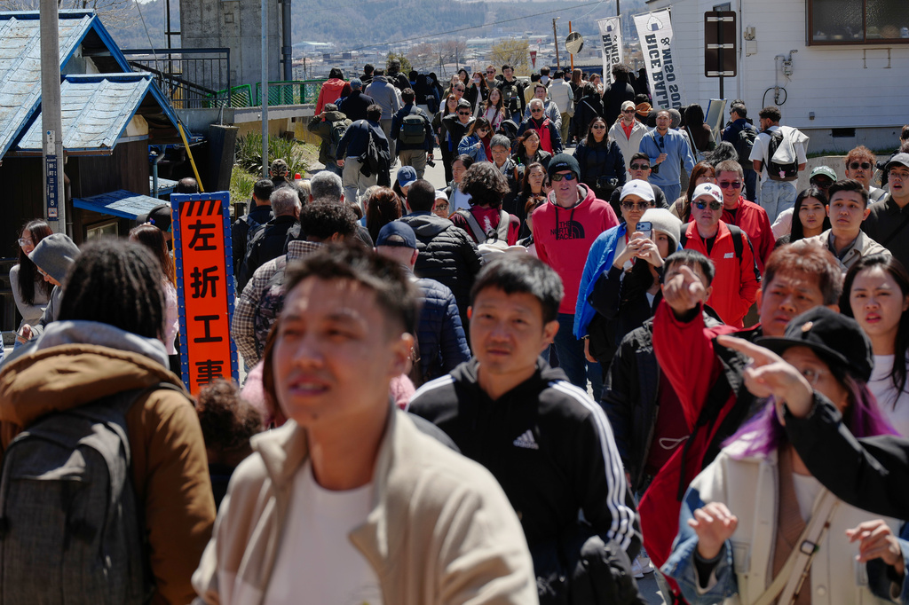 Foreign and Japanese visitors arrive to see cherry blossoms and Mount Fuji at Arakurayama Sengen Park on Wednesday, April 8, 2026, in Fujiyoshida, west of Tokyo. (AP Photo/Eugene Hoshiko)