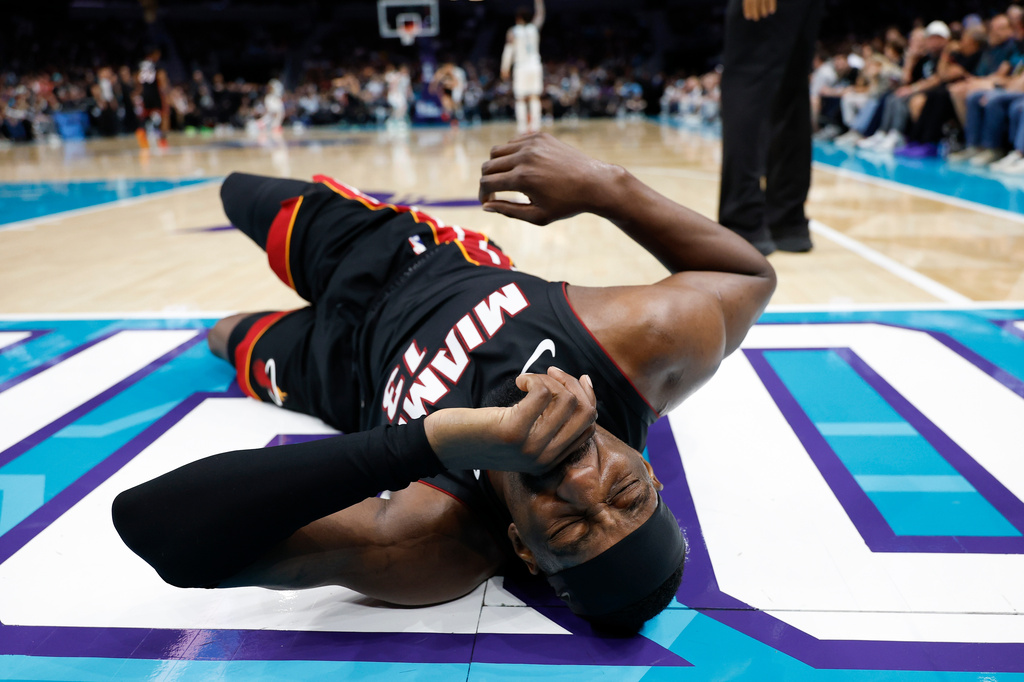 Miami Heat center Bam Adebayo (13) lies on the court during the first half of an NBA play-in tournament basketball game against the Charlotte Hornets in Charlotte, N.C., Tuesday, April 14, 2026. (AP Photo/Nell Redmond)