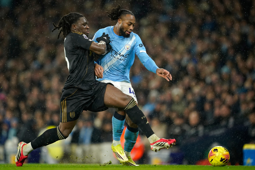 Fulham's Calvin Bassey, left, and Manchester City's Antoine Semenyo challenge for the ball during the English Premier League soccer match between Manchester City and Fulham in Manchester, England, Wednesday, Feb. 11, 2026. (AP Photo/Dave Thompson)