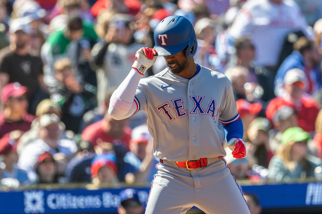 Texas Rangers' Andrew McCutchen tips his hat at home after hitting a three run home run in the fourth inning of a baseball game against the Philadelphia Phillies, Sunday, March 29, 2026, in Philadelphia. (AP Photo/Laurence Kesterson)