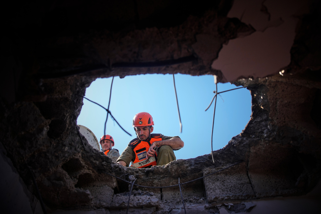 Officers from Israel's Home Front Command inspect a damaged apartment building after an Iranian missile strike in Petah Tikva, Israel, Tuesday, March 3, 2026. (AP Photo/Ohad Zwigenberg)