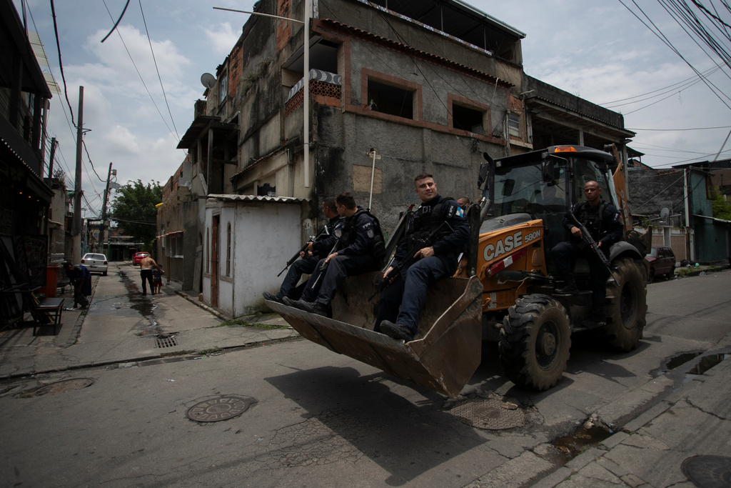 Police officers drive a bulldozer during a government-led operation to tear out barricades set up by drug trafficking gangs, at Cidade de Deus favela in Rio de Janeiro, Monday, Nov. 24, 2025. (AP Photo/Bruna Prado)