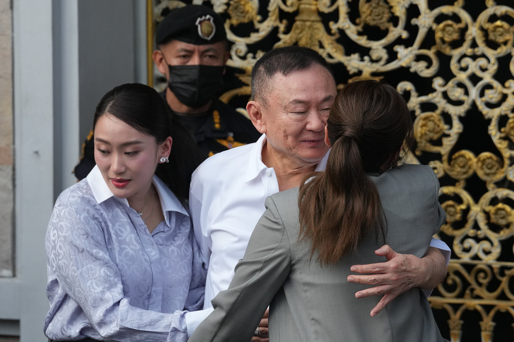 Former Thailand Prime Minister Thaksin Shinawatra, center, hugs his daughters, former Prime Minister Paetongtarn, left, and Pinthongta, after he was released on parole from a Bangkok prison in Bangkok, Thailand, Monday, May 11, 2026. (AP Photo/Sakchai Lalit)