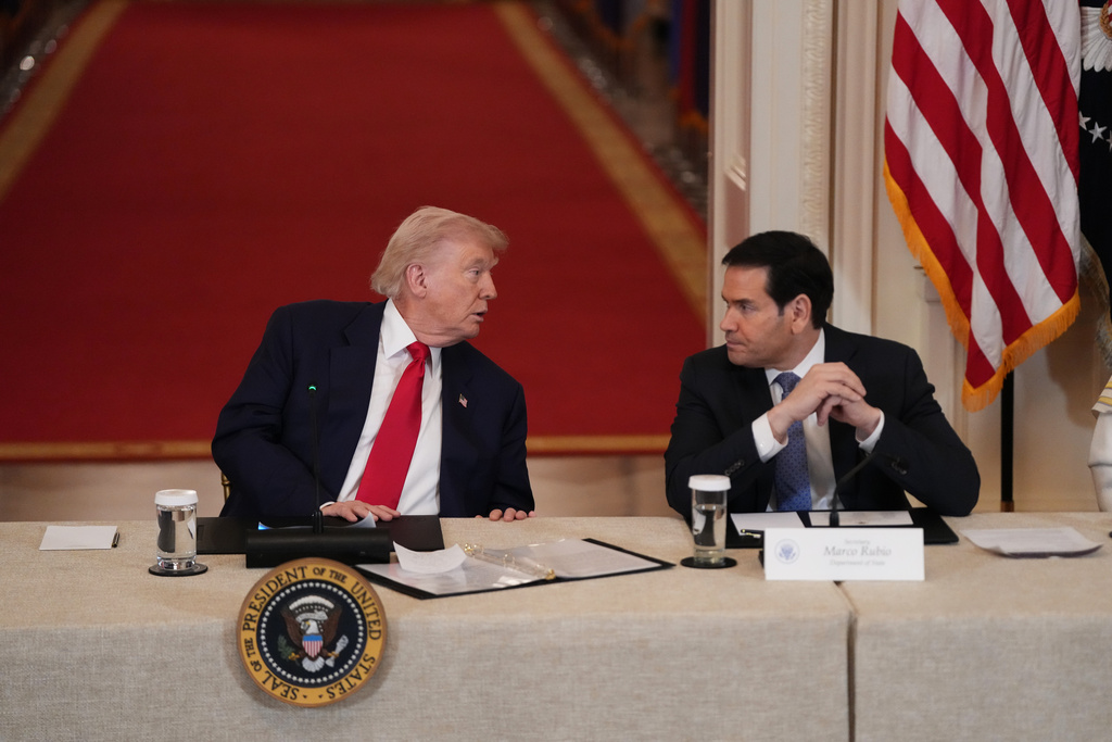President Donald Trump speaks with Secretary of State Marco Rubio during a roundtable discussion on college sports in the East Room of the White House, Friday, March 6, 2026, in Washington. (AP Photo/Julia Demaree Nikhinson)