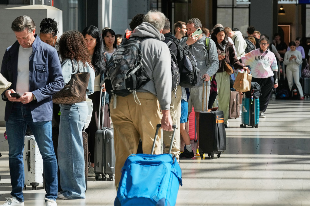 Amtrak passengers wait on line for their turn on the ticket office, in New York's Penn Station, Friday, May 29, 2026. (AP Photo/Richard Drew)