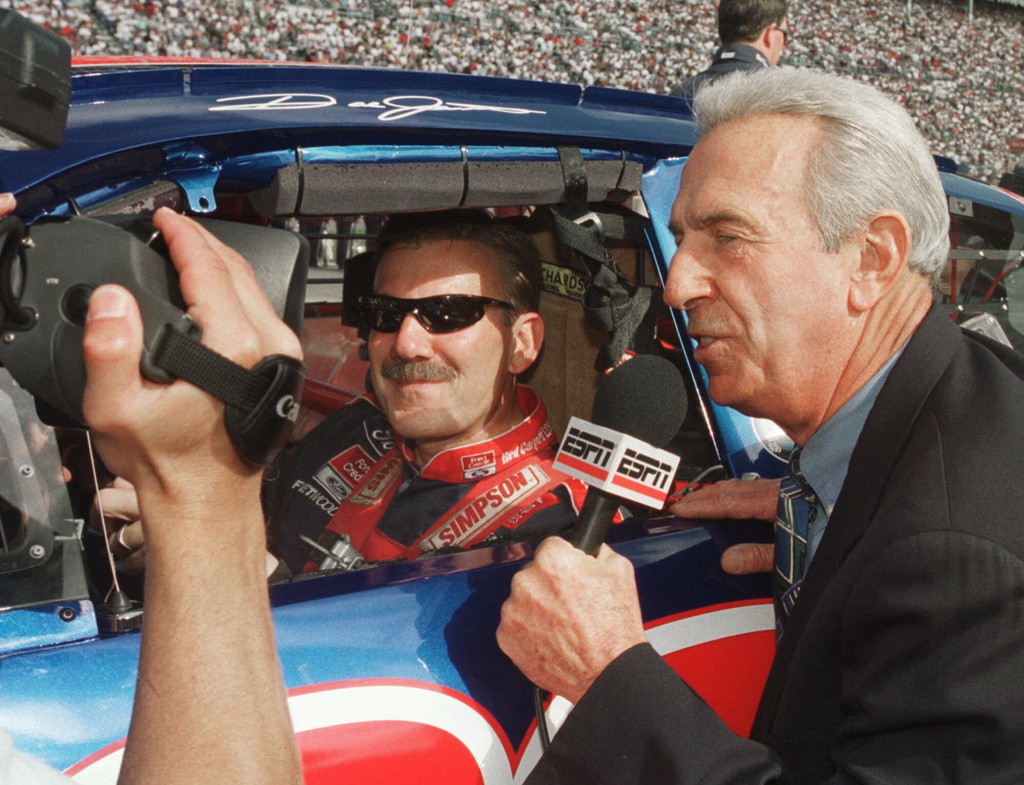FILE - Winston Cup Champion Dale Jarrett (88) is interviewed in his car on pit row by his father, Ned Jarrett, also a Winston Cup Champion, as he prepares for the start of the NAPA 500 at Atlanta Motor Speedway in Hampton, Ga., Nov. 21, 1999. (AP Photo/Ric Feld, File)