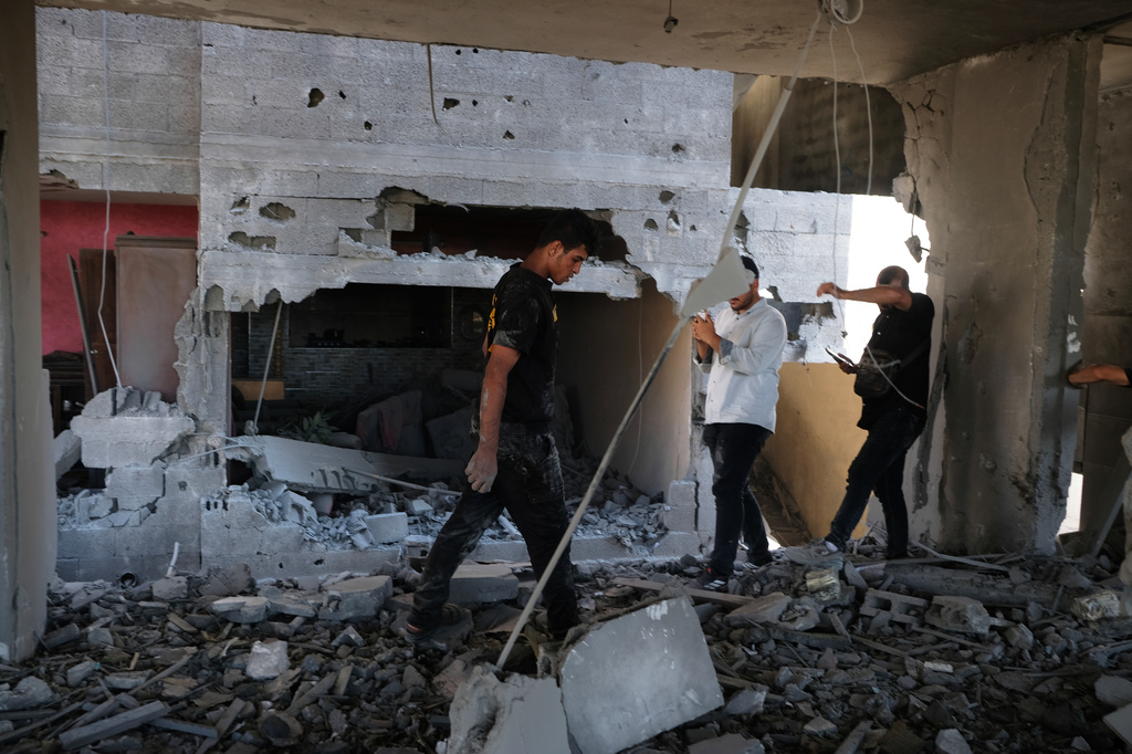 Residents inspect the site of an Israeli airstrike in Gaza city, Saturday, July 18, 2026. (AP Photo/Jehad Alshrafi)