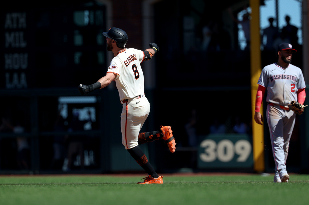 San Francisco Giants' Bryce Eldridge (8) rounds the bases after hitting a grand slam in front of Washington Nationals first baseman Luis García Jr. (2) during the ninth inning of a baseball game in San Francisco, Wednesday, June 10, 2026. (AP Photo/Jed Jacobsohn)