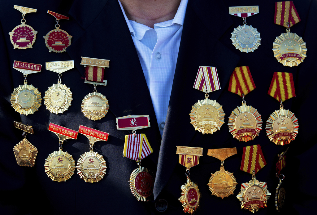 FILE - A guest of honor with medals on his coat arrives at his seat to watch a military parade to commemorate the 70th anniversary of the end of World War II in Beijing, on Sept. 3, 2015. (AP Photo/Andy Wong, Pool, File)