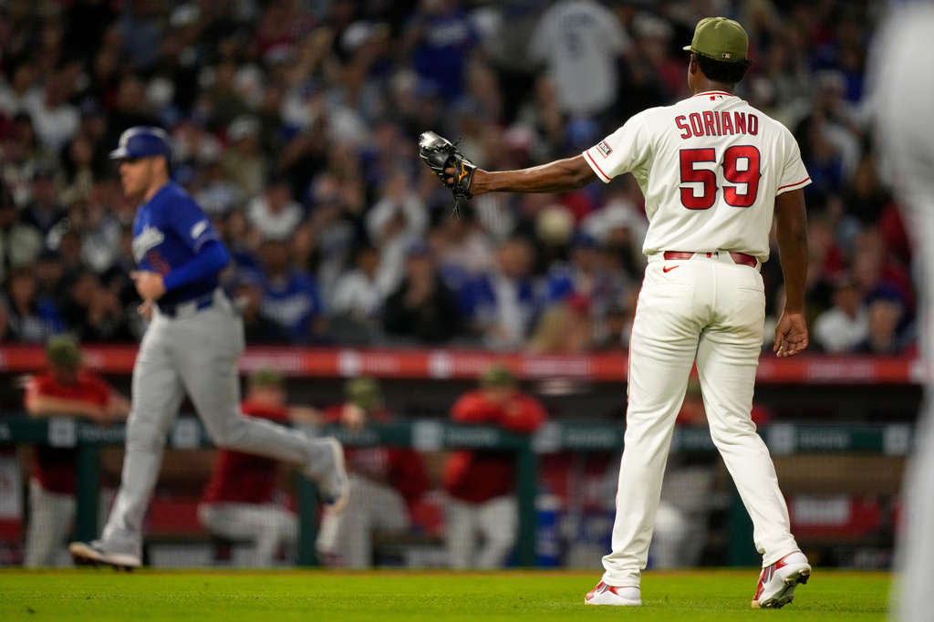 Los Angeles Angels pitcher José Soriano, right, stands by as Los Angeles Dodgers' Freddie Freeman heads home on a walk by Max Muncy during the sixth inning of a baseball game Saturday, May 16, 2026, in Anaheim, Calif. (AP Photo/Mark J. Terrill)