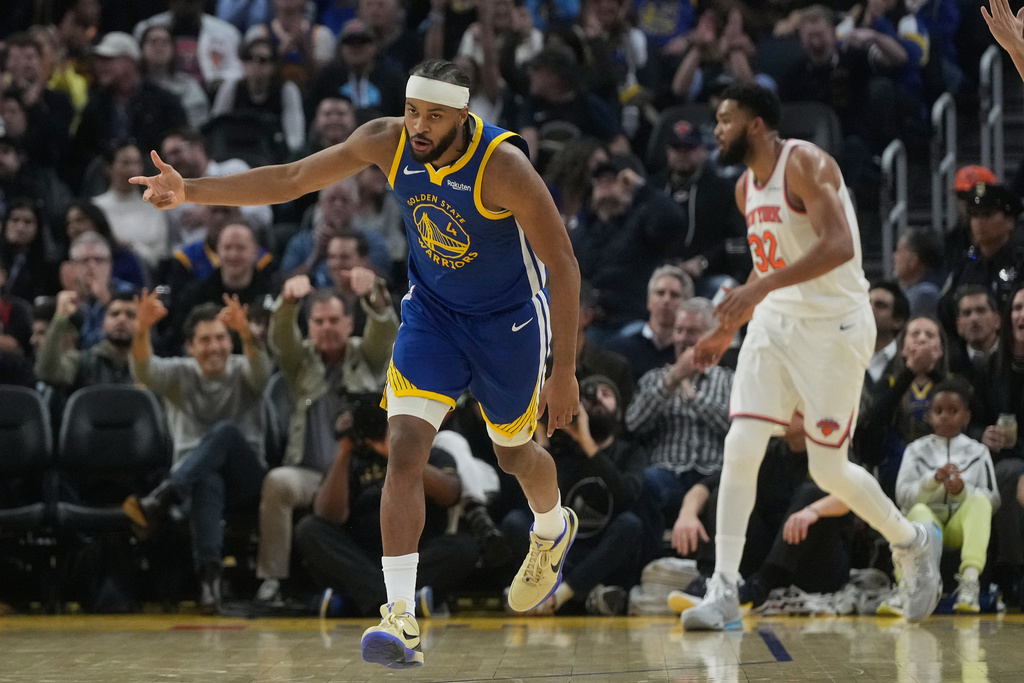 Golden State Warriors guard Moses Moody (4) reacts after making a 3-point basket in front of New York Knicks center Karl-Anthony Towns, right, during the first half of an NBA basketball game in San Francisco, Thursday, Jan. 15, 2026. (AP Photo/Jeff Chiu)