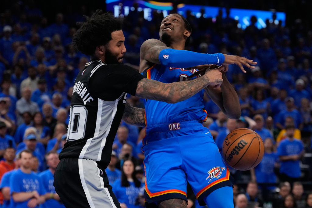 San Antonio Spurs forward Julian Champagnie (30) defends against Oklahoma City Thunder guard Jalen Williams (8) during overtime of Game 1 in a third-round NBA basketball playoffs series Monday, May 18, 2026, in Oklahoma City. (AP Photo/Tony Gutierrez)